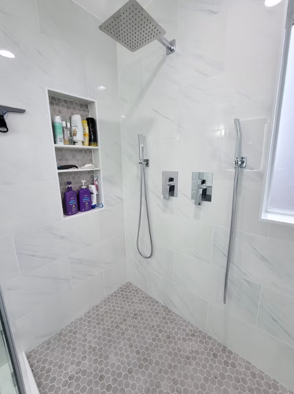 Walk-in shower interior with built-in shelving and hex floor tile, installed for a Kirkland homeowner