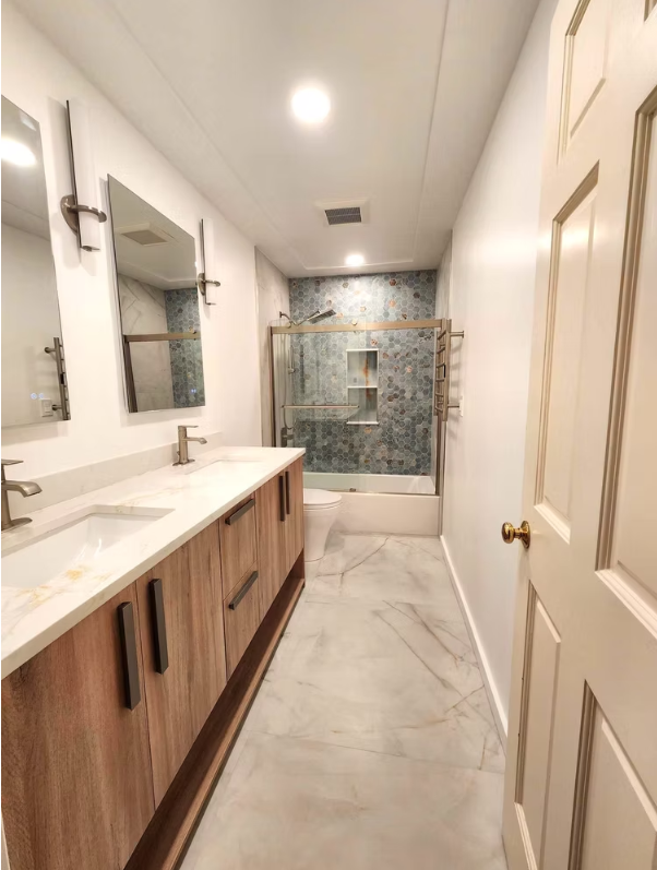 Dual rain shower heads with marble walls and built-in niche, installed for a Seattle homeowner